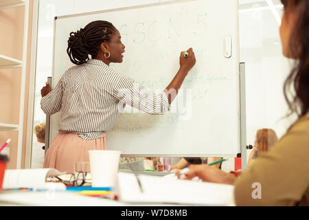 Competent teacher writing task on the board Stock Photo
