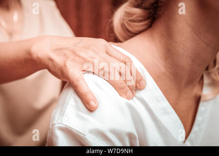 Back massage for a tired beautiful woman. Stock Photo