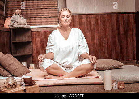 Smiling woman meditating before the tea ceremony. Stock Photo