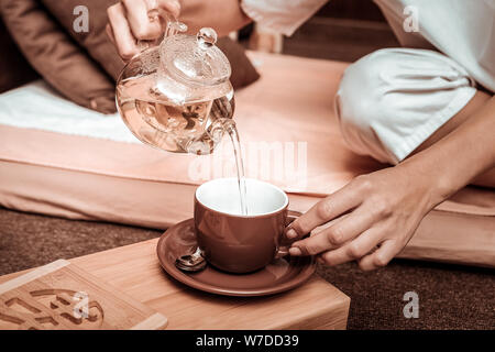 Woman pouring out tea before the tea ceremony. Stock Photo