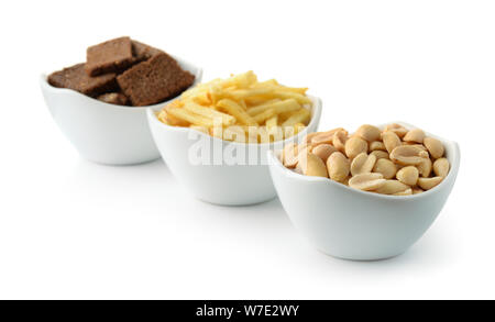 Potato sticks, salted peanuts and rye garlic croutons isolated on white Stock Photo