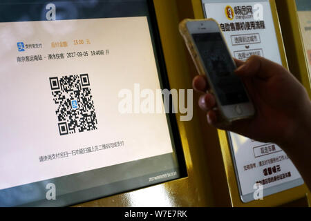 --FILE--A passenger uses the mobile app Alipay, the online payment service of Alibaba's Ant Financial, on his smartphone to scan the QR code to buy ti Stock Photo