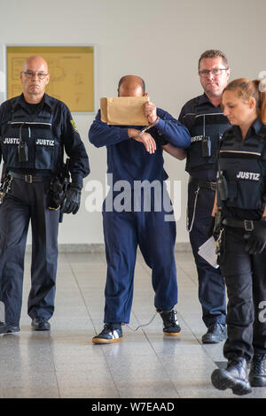 Magdeburg, Germany. 06th Aug, 2019. The defendant Bahaa M. is led to the courtroom in handcuffs by members of the judiciary. The 34-year-old is on trial for assault and battery. The accused, who comes from Syria, is accused of having injured people at tram stops with punches and kicks. Credit: Klaus-Dietmar Gabbert/dpa-Zentralbild/dpa/Alamy Live News Stock Photo