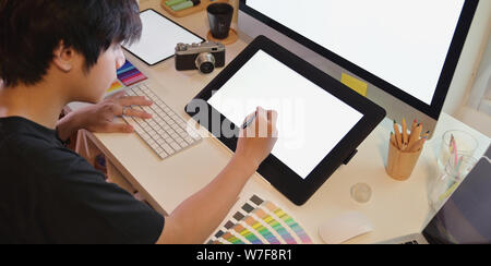 Young professional photographer editing his project in graphic tablet Stock Photo
