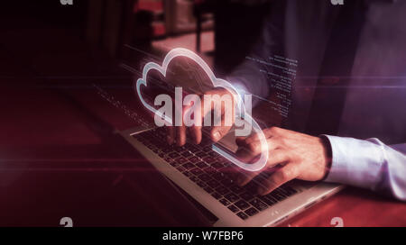 Man typing on laptop with data cloud hologram screen over keyboard. Data computing, online storage and document archive concept. Natural hand camera s Stock Photo