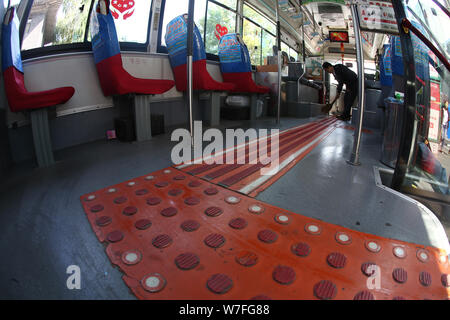 Chinese bus driver Yang Hongtao cleans the tactile paving designed and built by him on a bus in Changchun city, northeast China's Jilin province, 20 S Stock Photo