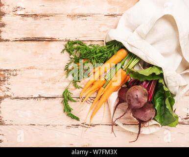 Fresh natural organic carrots beets bag made of cotton wooden rustic background. Natural eco friendly products concept. Stock Photo