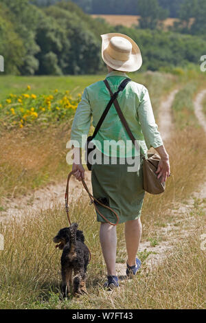 woman with dog walking to to Bungsberg near Schönwalde, Schleswig-Holstein, Germany Stock Photo