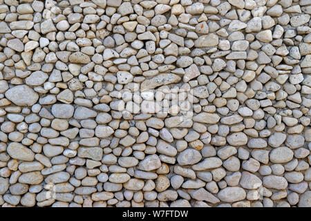 Pebbles arrangement inset into concrete. Stock Photo