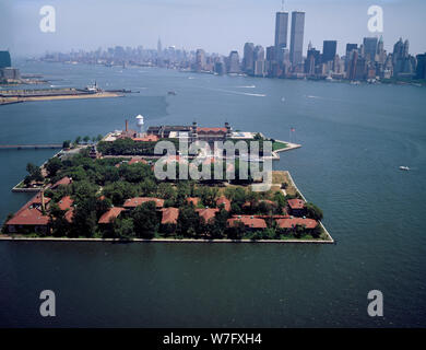 Aerial view of the Ellis Island immigration station showing the World Trade Center buildings in the distance. New York, New York Stock Photo