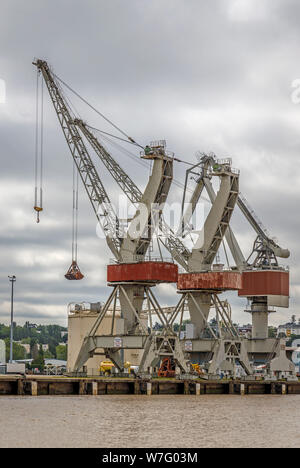 Dockside gantry cranes is use in the wharfs beside the Garonne River, Bordeaux, France. Heavy lift cranes within the industrial estate. Stock Photo