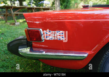 Collegeville, PA - July 28, 2019: Close up of the rear quarter panel of a red Triumph TR6 with the British flag logo photographed while it is sitting Stock Photo