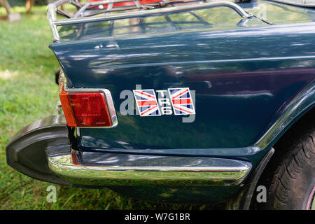 Collegeville, PA - July 28, 2019: Close up of the rear quarter panel of a dark green Triumph TR6 with the British flag logo photographed while it is s Stock Photo