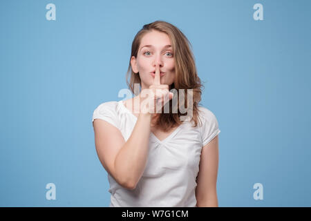 Shush, be silent. Serious lovely woman asks to keep secret information confidential. Conspiracy concept Stock Photo