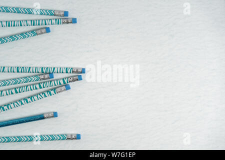back to school concept with patterned teal and white pencils on a mottled teal background Stock Photo
