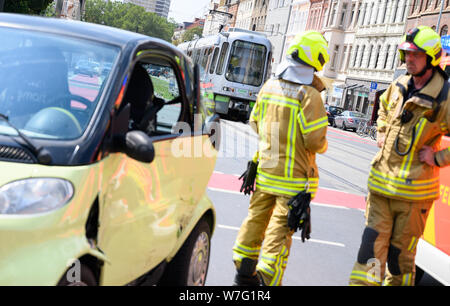 06 August 2019, Lower Saxony, Hanover: Firefighters look at a car that was hit by a tram. Photo: Christophe Gateau/dpa Stock Photo