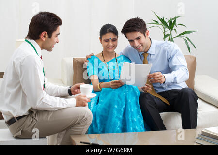 Young couple reading documents given by financial advisor Stock Photo