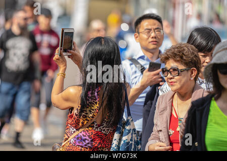 Cambridge, UK, August 1, 2019. Turists walking down and taking pictures at the street of Cambridge on a busy sunny day in front of Kings College Stock Photo