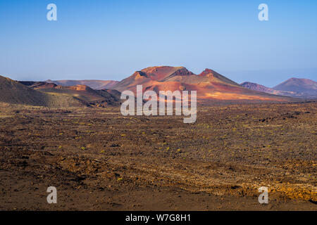 Spain, Lanzarote, Fantastic red colorful volcano surrounded by lava in timanfaya volcanic area Stock Photo