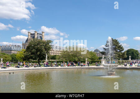Spring Tuileries gardens with fountain in front of Louvre palace, Paris, France Stock Photo