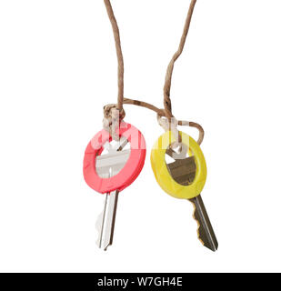 yellow and red keys with caps that are tied together isolated on white Stock Photo