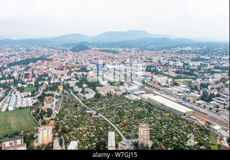 Aerial view of city Graz from helicopter drone with district Jakomini and the east railway station on a cloudy summer day in Austria, Europe Stock Photo
