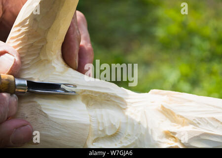 Old man hands with cutter for wood carving. Handmade concept. Nature background with copy space Stock Photo