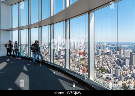 Visitors looking out over the city from the observation deck of the Mori Tower, Roppongi Hills, Tokyo, Japan Stock Photo