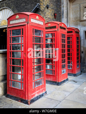 Three iconic traditional red British telephone boxes in London, England, UK Stock Photo