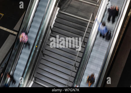 picture with long time exposure of an escalator with blurred commuters Stock Photo
