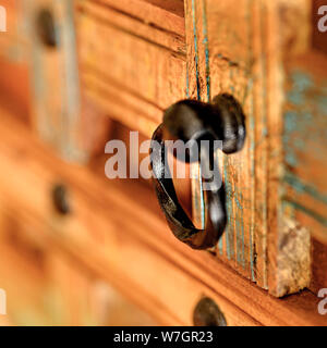 Details of a wooden chest made of recycled old ship planks with rivets and metal rings. Stock Photo