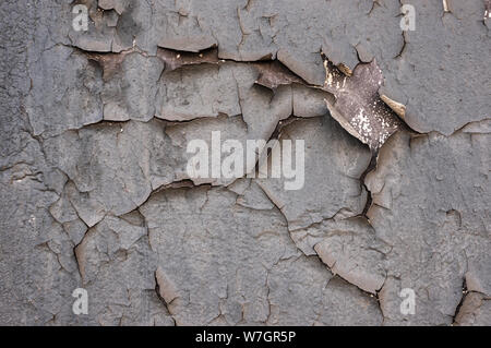 Old cracked paint on the concrete wall. Peeling paint on wall seamless texture. Pattern of rustic blue grunge material. Cracked wall with old layers o Stock Photo