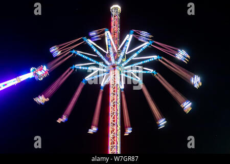 Fairground attraction in movement, motion blurred, during Columbian Festivals celebrations in the city of Huelva (Fiestas Colombinas de Huelva), to co Stock Photo