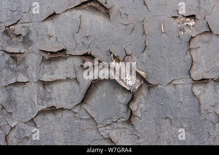 Old cracked paint on the concrete wall. Peeling paint on wall seamless texture. Pattern of rustic blue grunge material. Cracked wall with old layers o Stock Photo