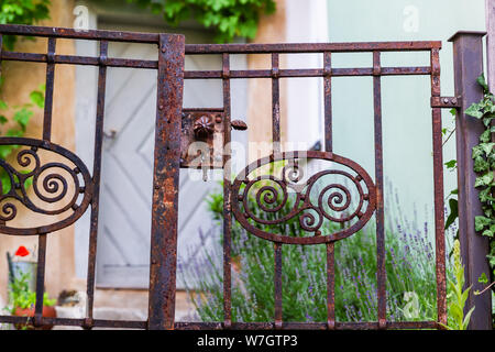 picture of a rusted wrought iron gate in front of a house Stock Photo