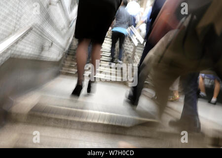 Blurred image of city workers people woman legs feet hurrying walking out of tube station at rush hour in the City of London England UK   KATHY DEWITT Stock Photo