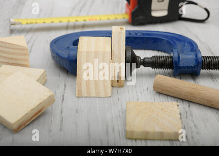 Close up, detail, clamp tool pressing wood shapes together for carpentry job, work, project, pressure, things Stock Photo