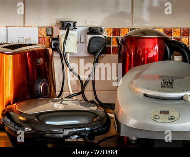 Home 13A double socket overloaded with socket adaptors and appliances. Stock Photo
