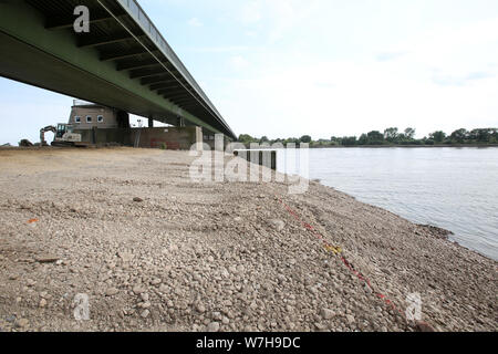 06 August 2019, Lower Saxony, Rönne: Workers have built up an area at the foundation of the Elbe weir. Since 02.08.2019, water had to be drained in order to reduce the water pressure on the structure and to relieve the dam. As a result, the water level dropped and shipping had to be stopped. Photo: Bodo Marks/dpa Stock Photo