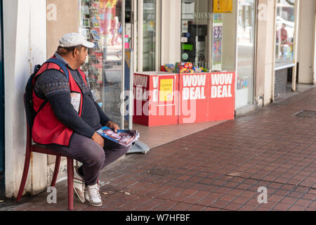 08/04/2019 Portsmouth, Hampshire, UK A big issue seller in an english high street Stock Photo