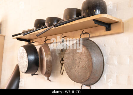 Vintage pots and pans hanging on a wall in an old kitchen Stock Photo