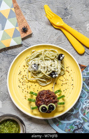 Cutlet look like a spider with pesto pasta for Halloween Stock Photo