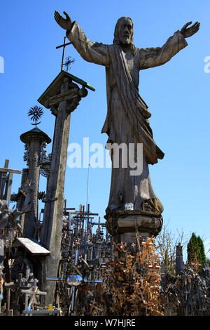 Wooden Christ sculpture on the Hill of crosses. A site of catholic pilgrimage in Siauliai, Lithuania. A large number of crosses and crucifixes. Monume Stock Photo