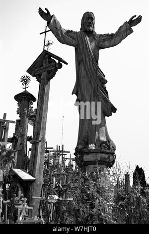 Wooden Christ sculpture on the Hill of crosses. A site of catholic pilgrimage in Siauliai, Lithuania. A large number of crosses and crucifixes. Monume Stock Photo