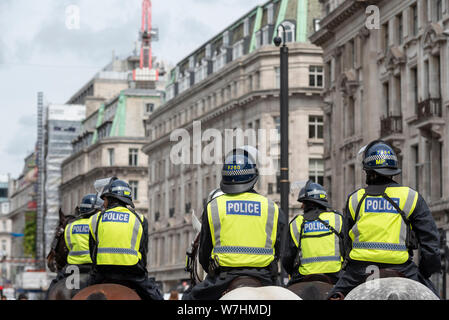 Mounted Police monitoring protesters at Free Tommy Robinson protest rally In London, UK. Watching. Police on horseback. Horses Stock Photo