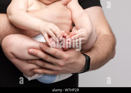 Father keeping little baby in hands and kissing kid Stock Photo