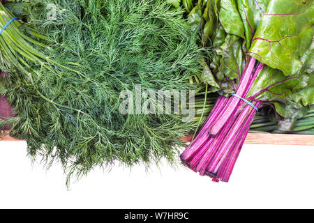 top view of bundles of beet tops and fresh dill close-up on wooden tray isolated on white background Stock Photo