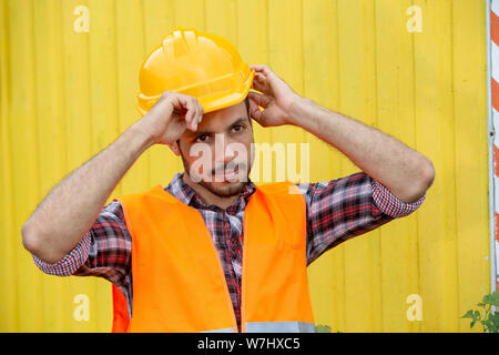 handsome construction worker with yellow helmet and orange vest Stock Photo