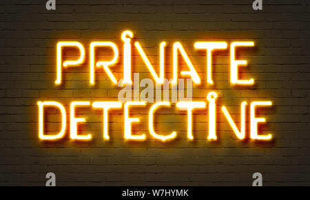 Private detective neon sign on brick wall background Stock Photo
