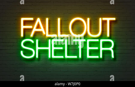 Fallout shelter neon sign on brick wall background Stock Photo